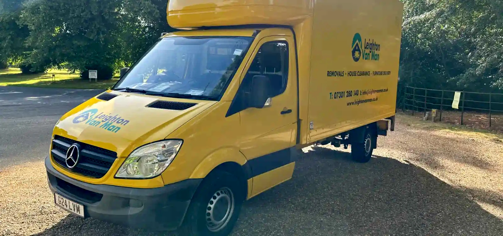 Removals Leighton Buzzard yellow Luton van with tail lift parked under trees in Leighton Buzzard